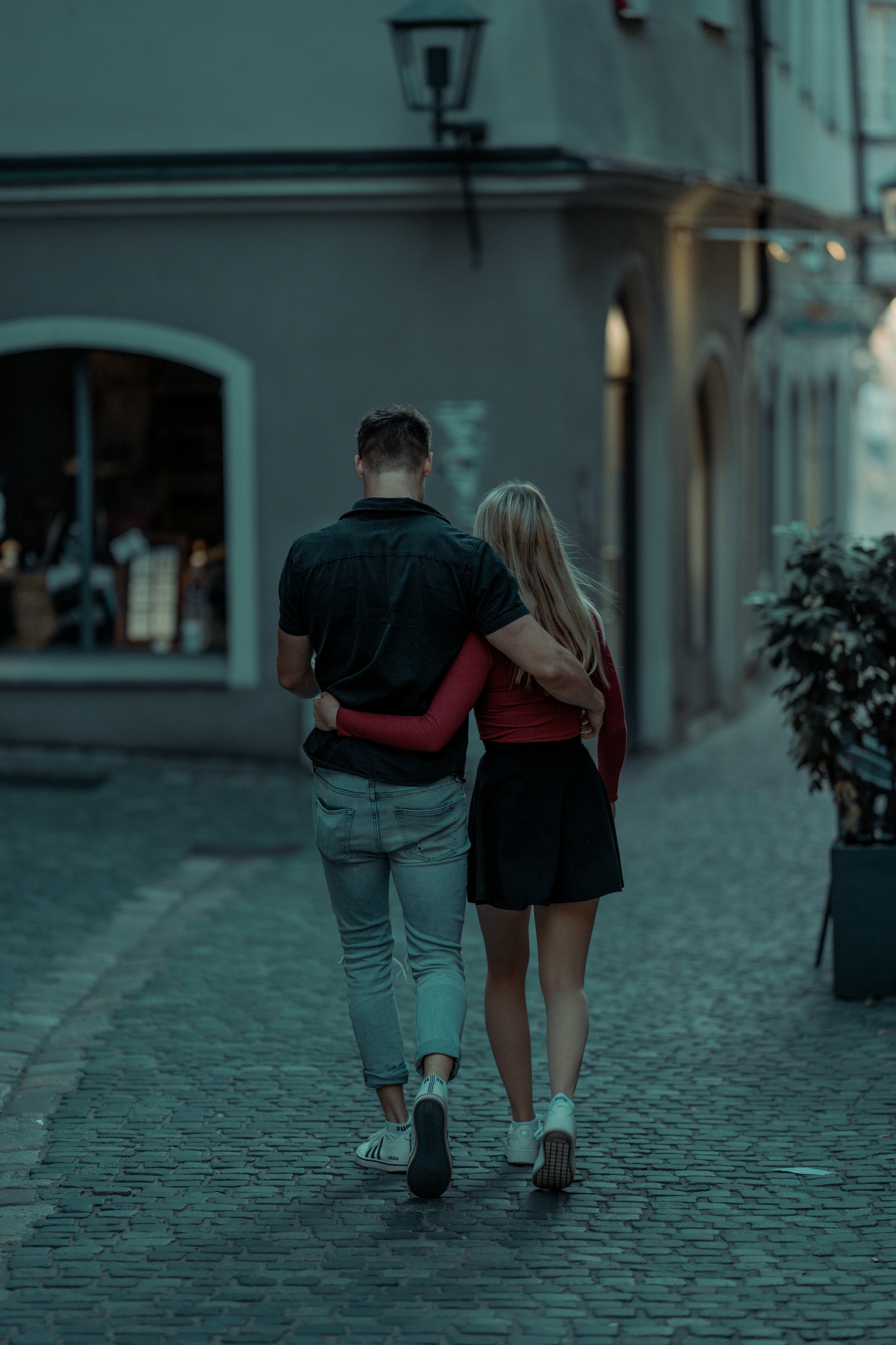 couple walking on sidewalk during daytime